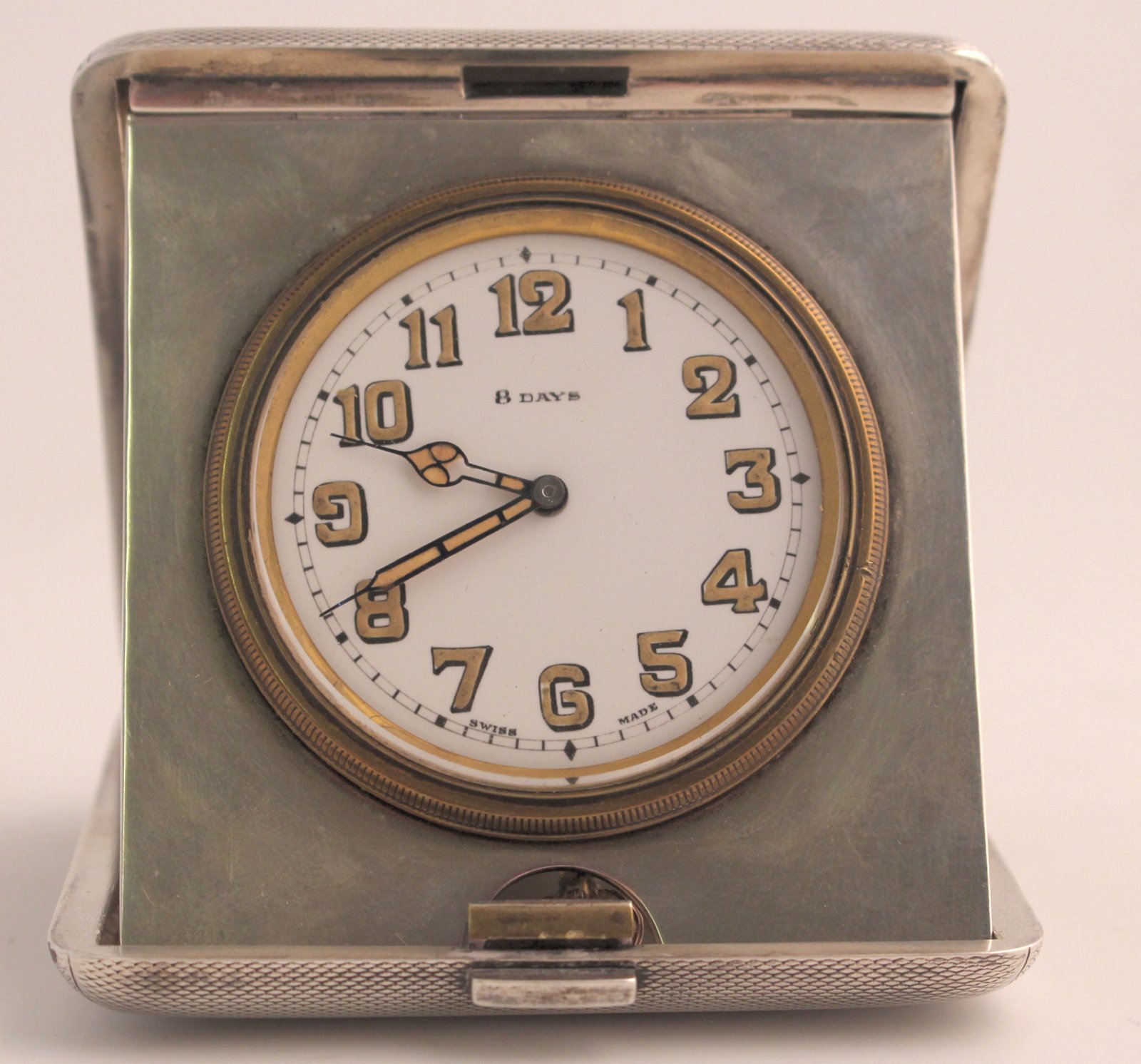 Antique 8day silver travel clock in engine turned folding case, HM